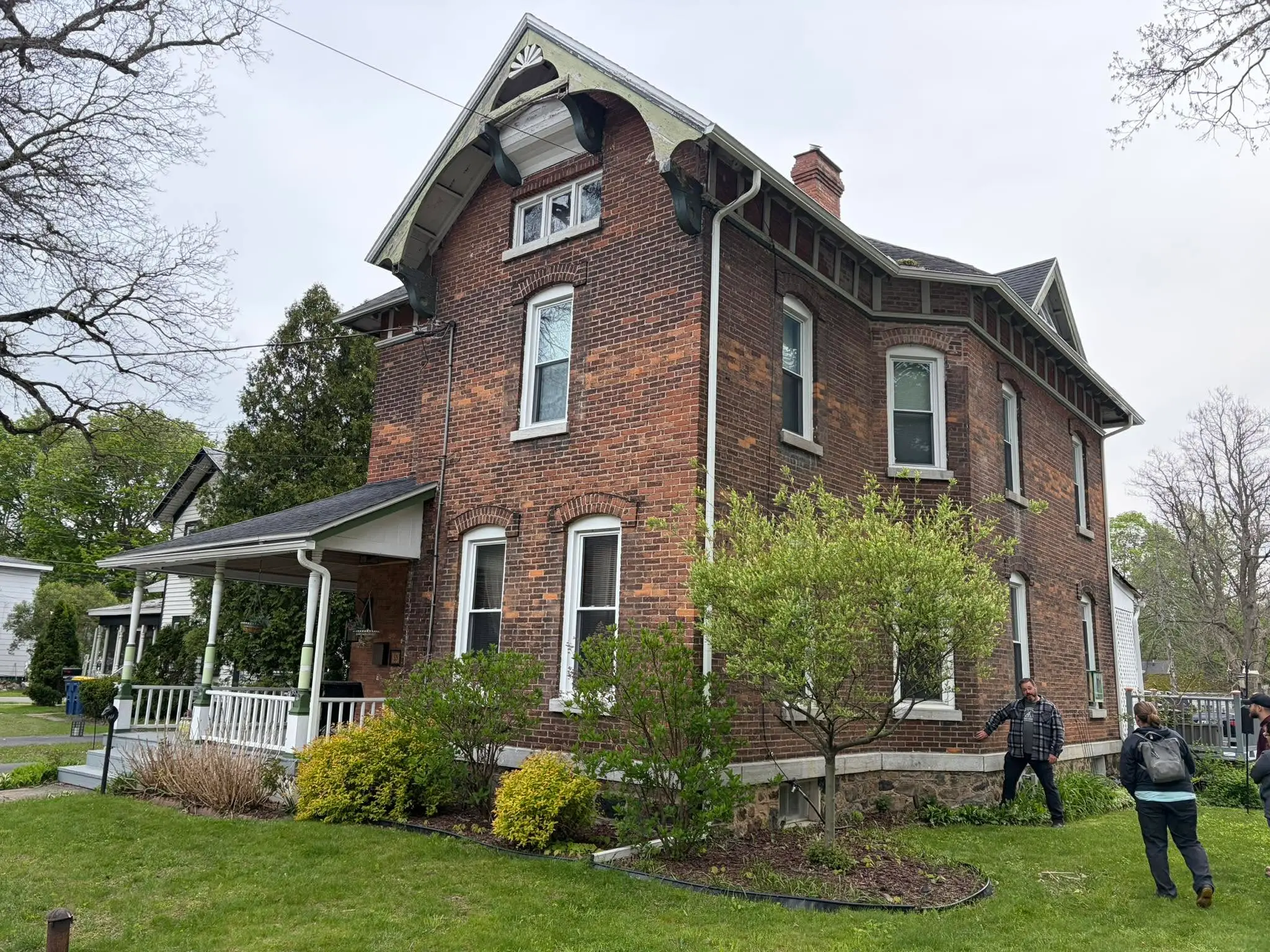 Home inspectors examining the exterior of a historic brick home in Central New York