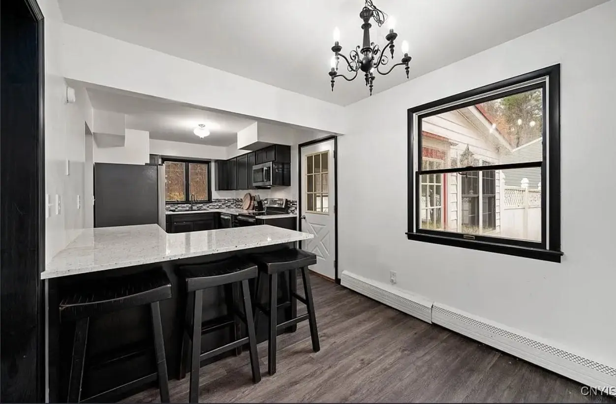 Kitchen and dining area with breakfast-bar peninsula and bar stools