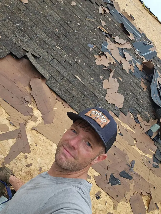 Weber Construction roofer tearing old shingles off down to the deck
